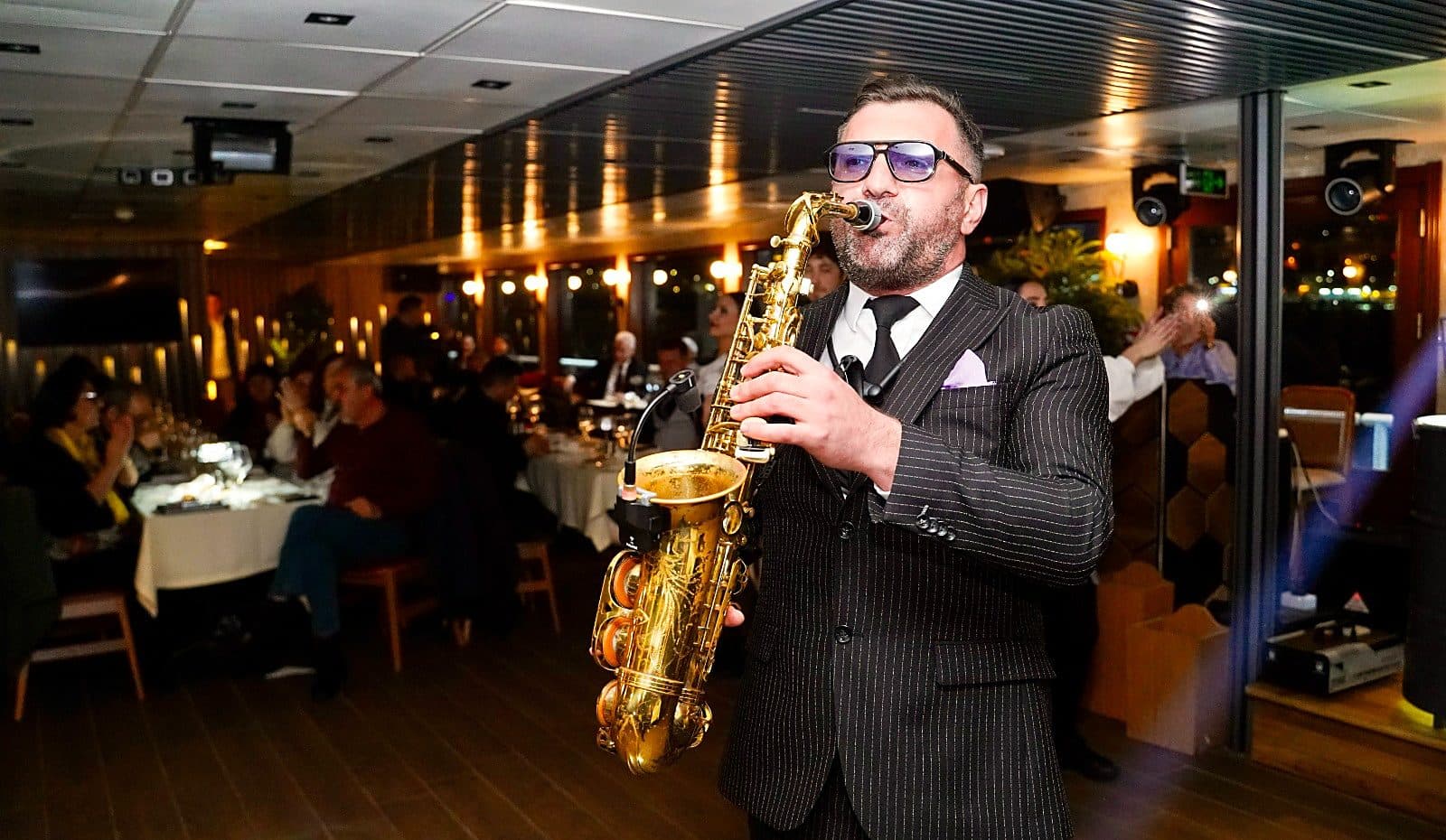 Saxophonist performing among the dinner tables on board